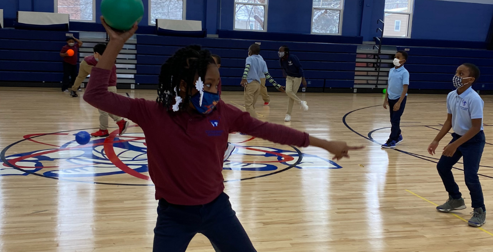 Syracuse Academy of Science and Citizenship 2nd grade Atoms practice their overhand throw in gym class.