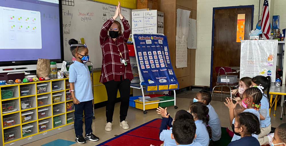 Syracuse Academy of Science and Citizenship elementary school students work together to determine the emotion on the Hedbanz by using facial expressions and body language.