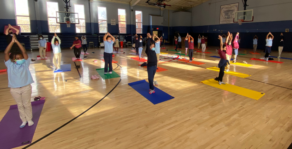 Syracuse Academy of Science and Citizenship elementary school participate in yoga sessions and mindfulness practices such as meditation during their physical education class.